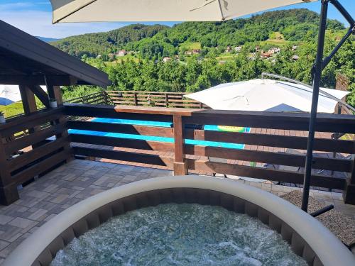 a plunge pool with an umbrella and a hot tub at Kuća za odmor MARE in Lepoglava