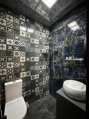 a bathroom with a white toilet and a sink at Lovely flat near the Boulevard Center of Baku in Baku