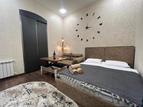 a bedroom with a bed and a clock on the wall at Lovely flat near the Boulevard Center of Baku in Baku