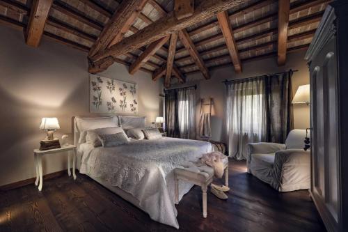 Un dormitorio con una cama grande en una habitación con techos de madera. en Dimora di Campagna en Casale sul Sile