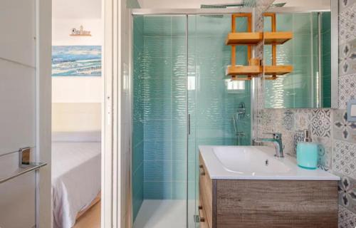 ein Bad mit einem Waschbecken und einer Glasdusche in der Unterkunft PETRA BIANCA Charming House in Mattinata