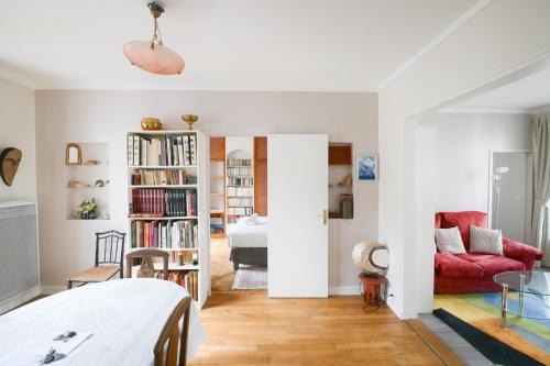 un salon avec un canapé rouge et une chambre dans l'établissement Harmonie Intemporelle, à Paris