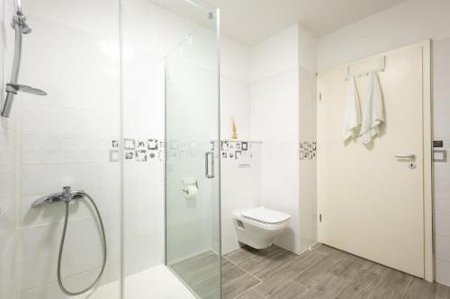 a white bathroom with a shower and a toilet at Fina Apartment in Opatija