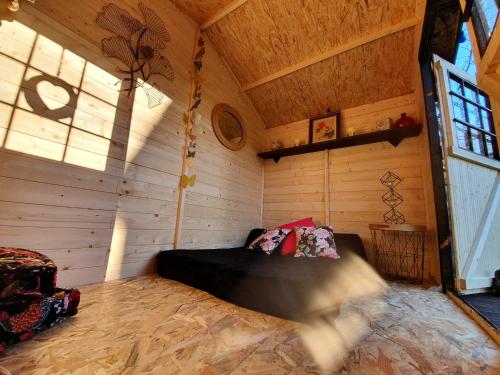 Cette chambre comprend un lit dans une cabane en bois. dans l'établissement Au Rocher Troué, à Millau