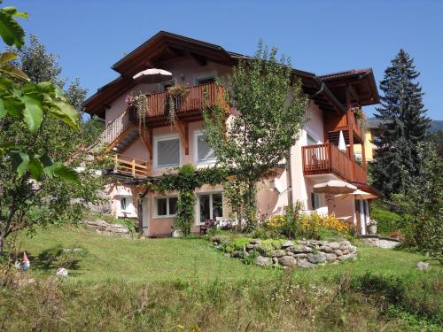 a large house with a balcony on a hill at FeWo in der Weinleiten in Millstatt
