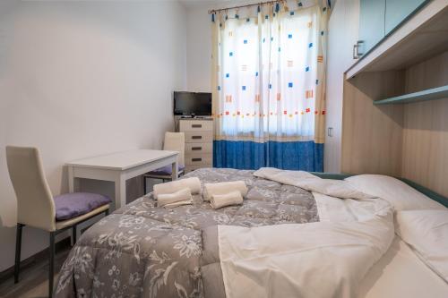a bedroom with a large bed with a chair and a desk at Casa Olga in San Bartolomeo al Mare