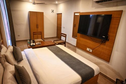 a hotel room with a bed and a flat screen tv at Hotel Lake View Chandigarh in Chandīgarh