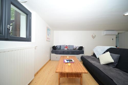a living room with a black couch and a table at Chalet Appartement Les Isards in Saint-Lary-Soulan