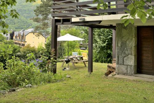 a patio with a table and an umbrella at Chalet Appartement Les Isards in Saint-Lary-Soulan