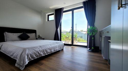 Hue House Stay - Villa phòng lẻ hoặc nguyên căn في Thôn Trường Giang: غرفة نوم بها سرير ونافذة كبيرة