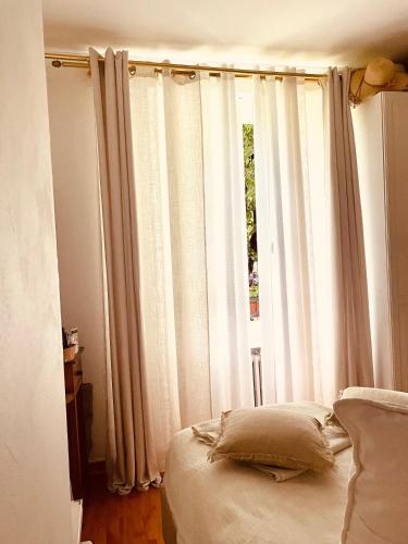 une chambre avec un lit et une fenêtre avec des rideaux dans l'établissement Plein cœur du village olympique, à Saint-Ouen