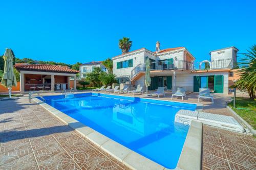 a large swimming pool in front of a house at Villa Rasotica Relaxing Villa with Heated Pool, Perfect for Families in Sumartin