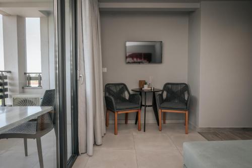 a room with a table and chairs and a tv at Elizabeth Queen Luxury Rooms in Paralia Katerinis