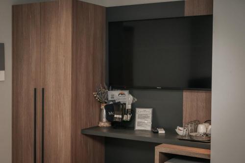 a room with a large television on a shelf at Elizabeth Queen Luxury Rooms in Paralia Katerinis