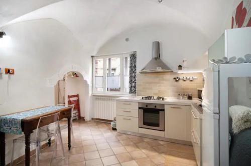a kitchen with a table and a refrigerator at Le Trifore in Ventimiglia