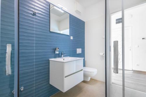 ein Badezimmer mit einem weißen Waschbecken und einem WC in der Unterkunft Anchor Apartman by HelloBalatonlelle in Balatonlelle