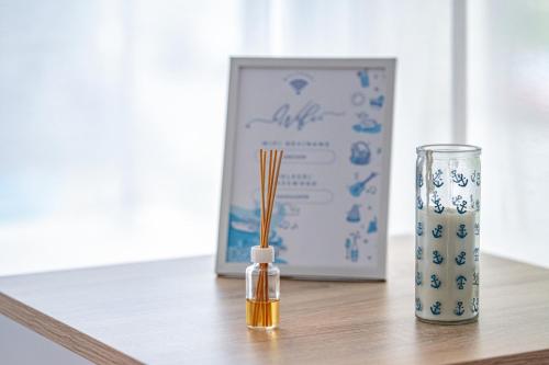 a wooden table with a vase and a bottle on it at Anchor Apartman by HelloBalatonlelle in Balatonlelle
