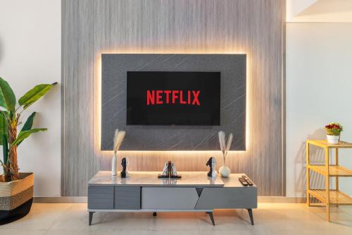 een woonkamer met een netflix-bord aan de muur bij Furnished Studio In Arch Tower, Jlt Near Metro in Dubai