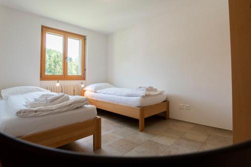 a room with two beds and a window at Haus Bella Vista in Riederalp
