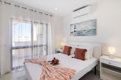 a white bedroom with a bed and a window at Penthouse Paradise - Praia da Rocha in Portimão