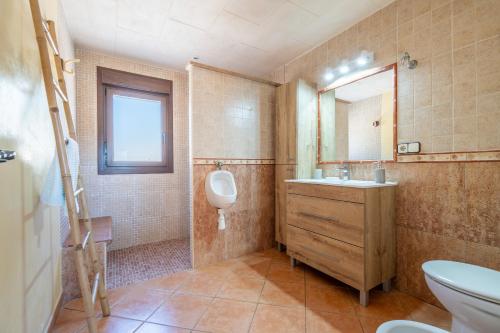 een badkamer met een toilet, een wastafel en een spiegel bij Capricho in Portocolom