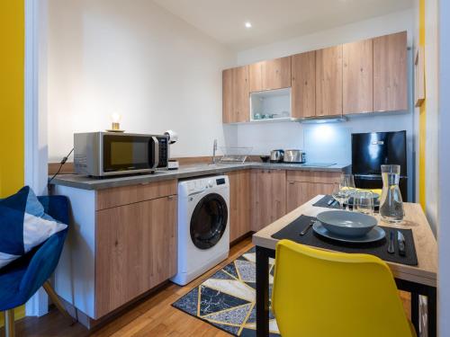une cuisine avec un lave-linge et un micro-ondes dans l'établissement LE DEDIEU - HYPERCENTRE GARAGE GRATUIT WiFi NETFLIX AMAZON PRIME, à Villeurbanne