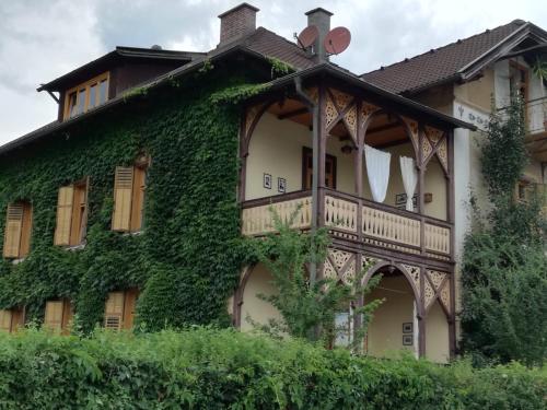 a house covered in ivy with a balcony at Villa Martiny in Seeboden
