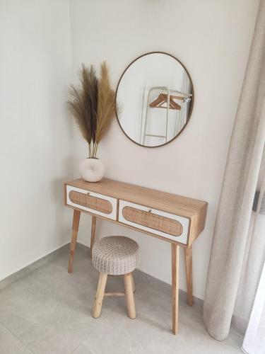 a wooden dressing table with a mirror and a stool at Noelia House Ammouliani in Ammouliani