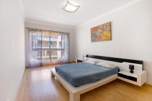 Una habitación blanca con una cama y una ventana en Apartamento Armação de Pêra, en Armação de Pêra