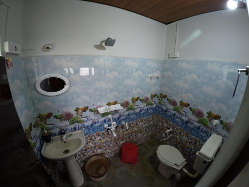 a bathroom with a toilet and a sink at Lara Homestay in Gonebidu