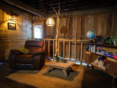 a living room with a leather chair and a table at Ne Pakku Manja Family Home in Rantepao