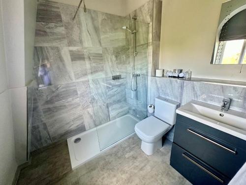 a bathroom with a shower and a toilet and a sink at The Spa Hotel in Royal Tunbridge Wells