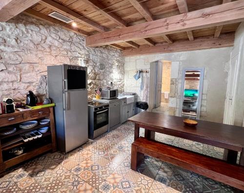 cocina con nevera de acero inoxidable y mesa de madera en Hotel Majestic, en Nimes