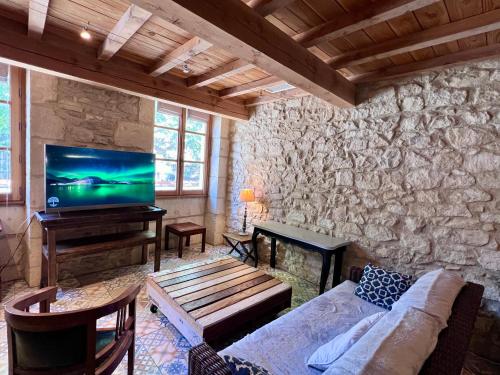 ein Wohnzimmer mit einem Sofa und einem Flachbild-TV in der Unterkunft Hotel Majestic in Nîmes