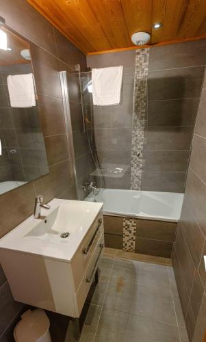 a bathroom with a sink and a bath tub at Les Chalets d'Adelphine & SPA in Les Gets