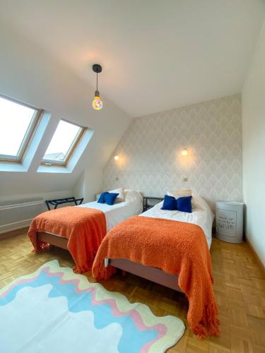 - une chambre mansardée avec 2 lits et un tapis dans l'établissement Black Rock Champagne, à Moussy