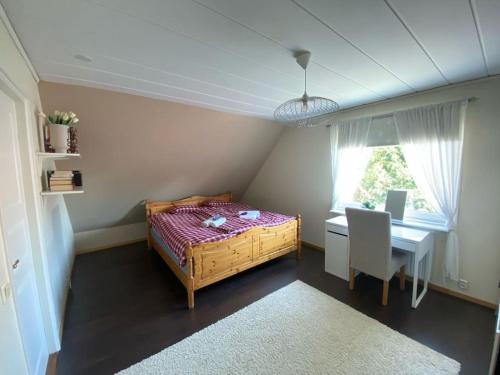 a bedroom with a bed and a desk and a window at Kalmar - Bergavik in Kalmar