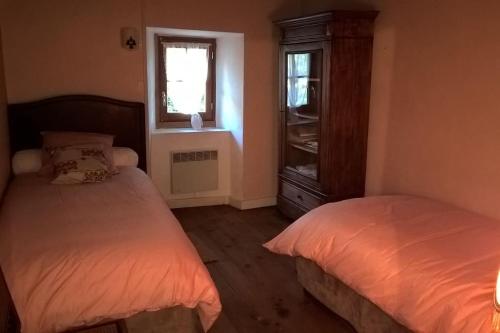 une chambre avec deux lits et une fenêtre dans l'établissement Gite rustique de montagne !, à Bézins-Garraux