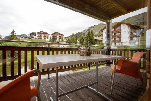 a table and chairs on a balcony with a view at Haus Bella Vista in Riederalp