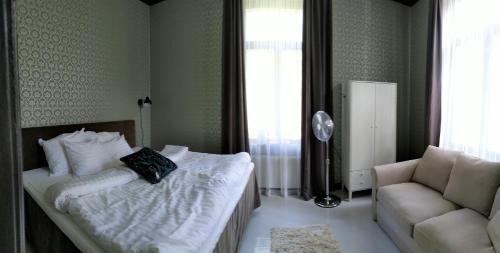 a bedroom with a bed and a couch and a chair at Hotelli Punkaharju in Punkaharju