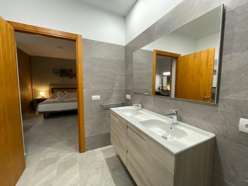 a bathroom with a sink and a mirror and a bed at Agroestancia Es Peieret in Sant Francesc Xavier
