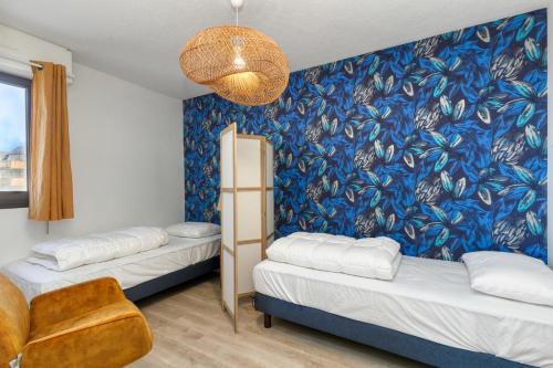 Una habitación con dos camas y una pared azul. en Appartement vue mer 20m de la plage, en Le Croisic