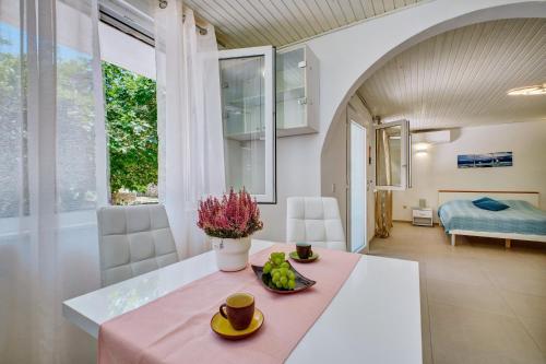a dining room with a table with a bowl of fruit on it at Deja near centar and Čikat bay with private parking in Mali Lošinj