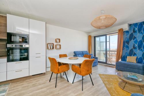 un salon avec une table et des chaises dans l'établissement Appartement vue mer 20m de la plage, au Croisic