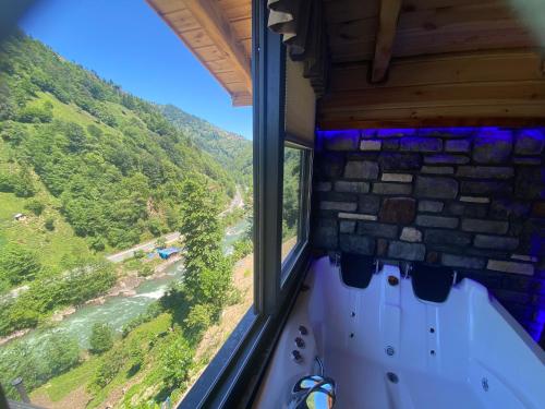 um quarto com uma janela com vista para um rio em Sisorti süit bungalov em Rize