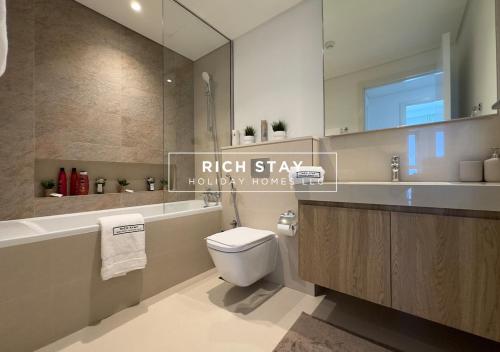 a bathroom with a toilet and a sink and a mirror at Incredible 1BR apartment, Downtown Views II by Rich Stay in Dubai