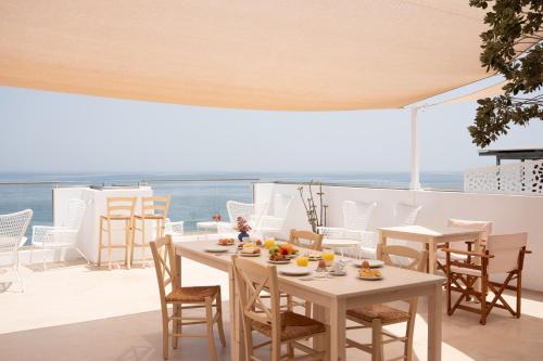 uma mesa e cadeiras numa varanda com o oceano em Sea Breeze Hotel em Hersonissos