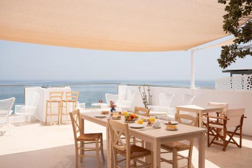 a table and chairs on a balcony with the ocean at Sea Breeze Hotel in Hersonissos