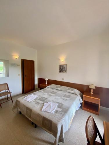 a bedroom with a large bed and two chairs at Bed & Breakfast Alex in Capoliveri