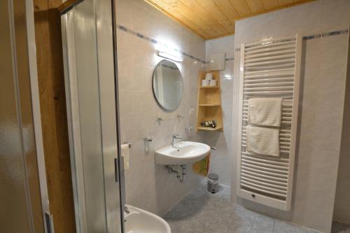 a bathroom with a sink and a toilet and a mirror at SCHETERERHOF in San Candido